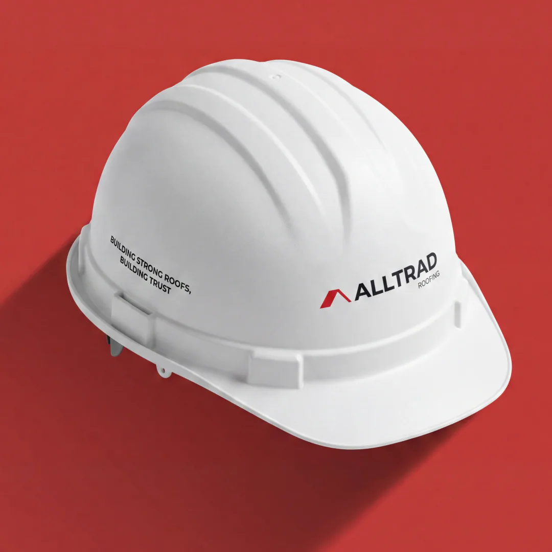 Alltrad Roofing branded hard hat on a red background
