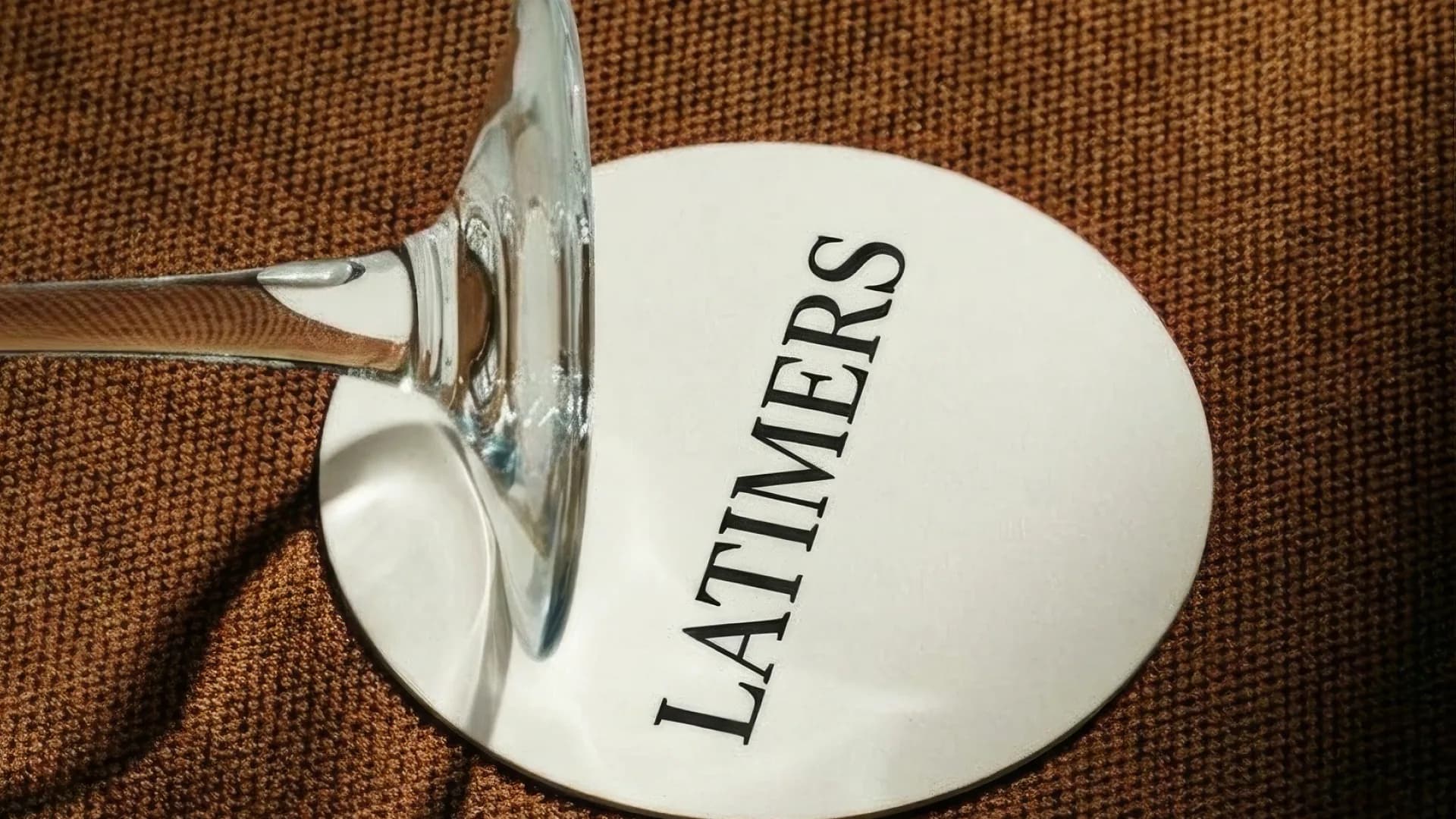Latimers wordmark on the base of a wine glass