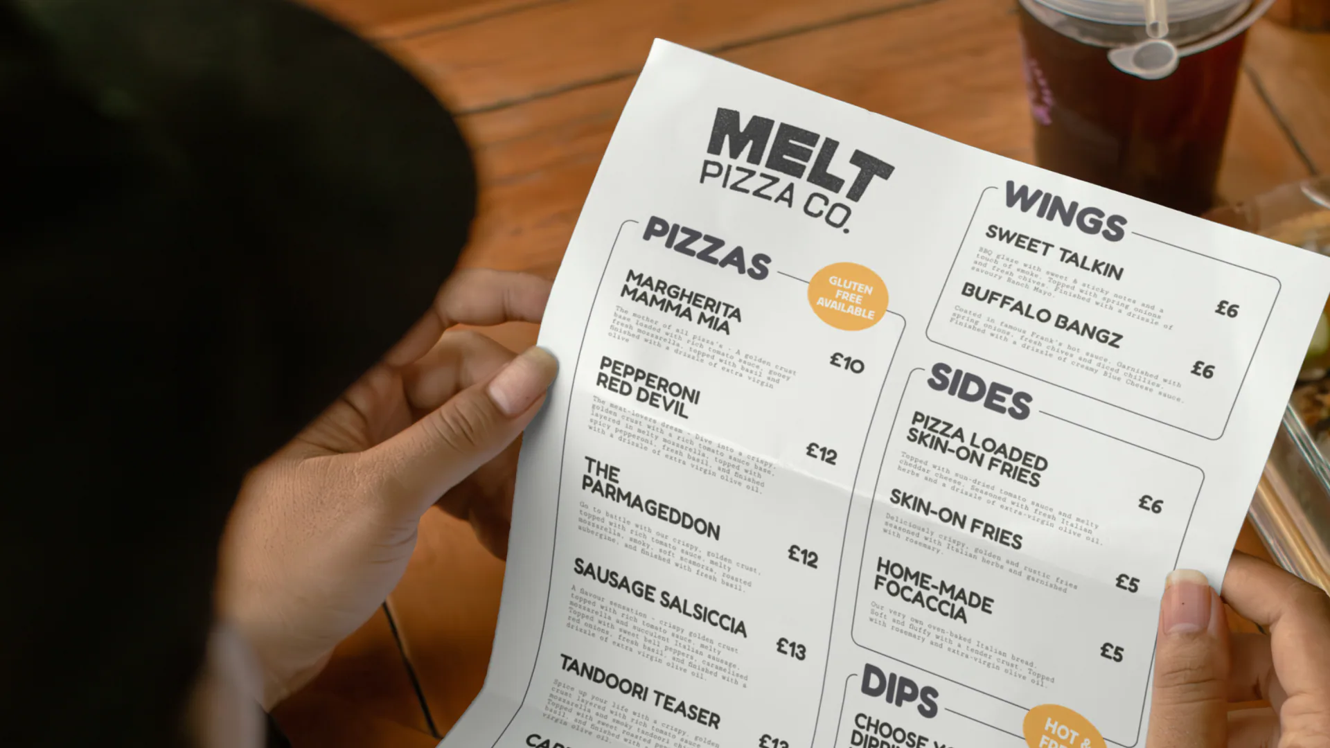 Customer reading the Melt Pizza Co printed menu