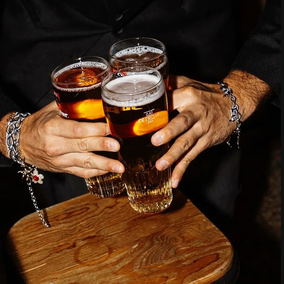 Hands holding drinks at the Orange Rooms bar