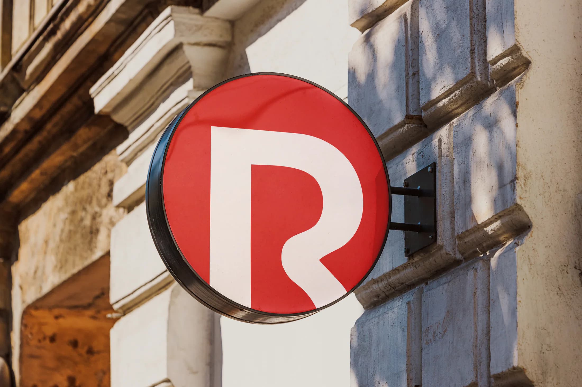 Remigo circular R sign mounted on a building facade