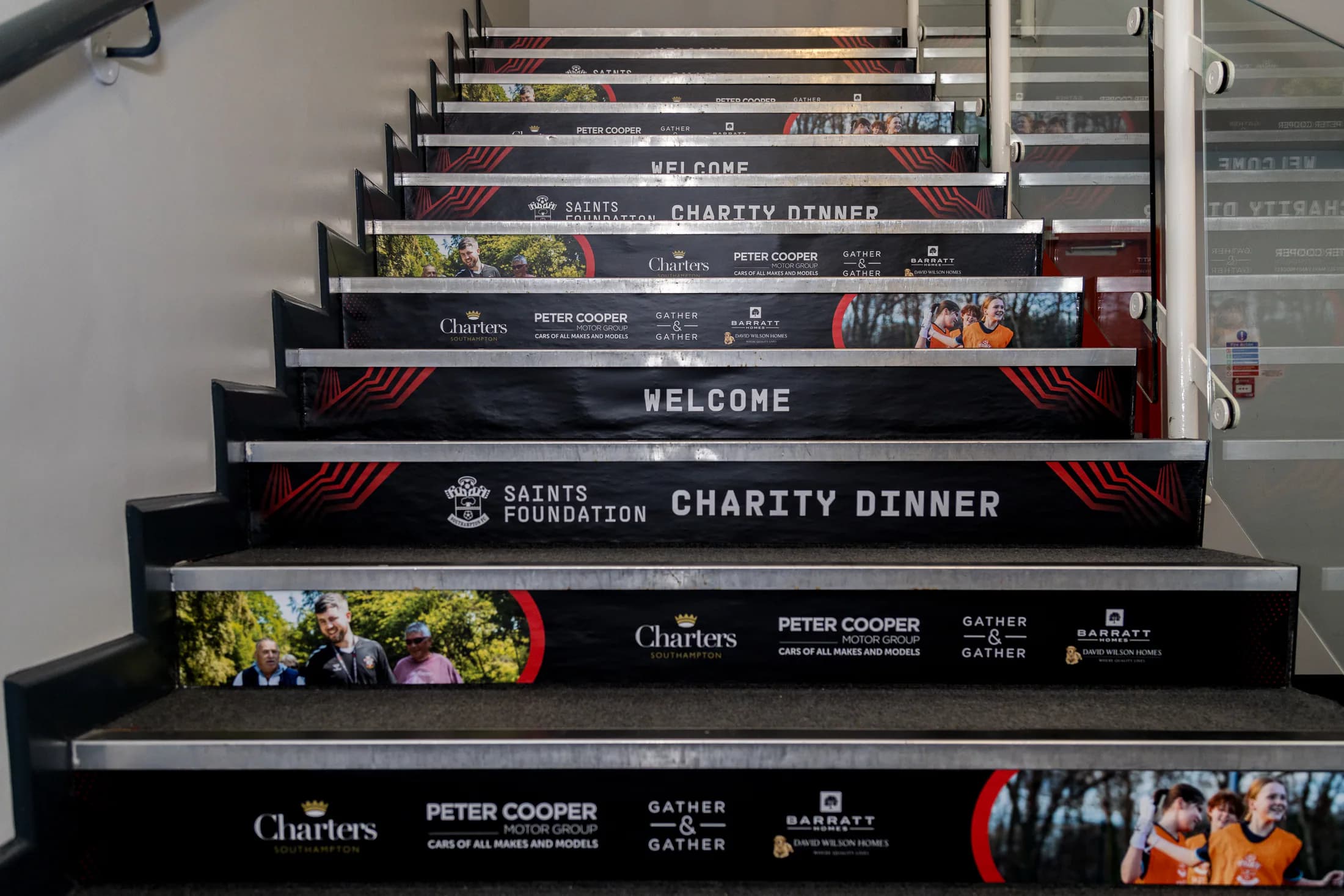 Branded stair graphics welcoming guests to the Saints Foundation Charity Dinner