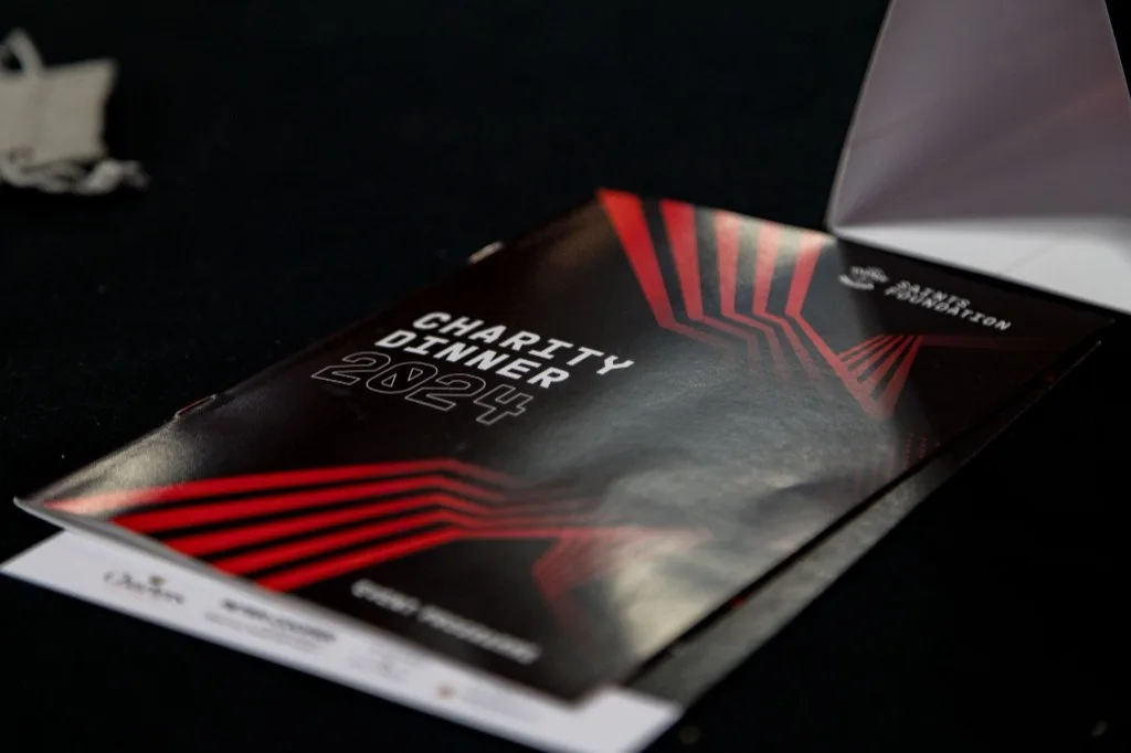 Saints Foundation Charity Dinner 2024 event programme cover with radiating-lines motif